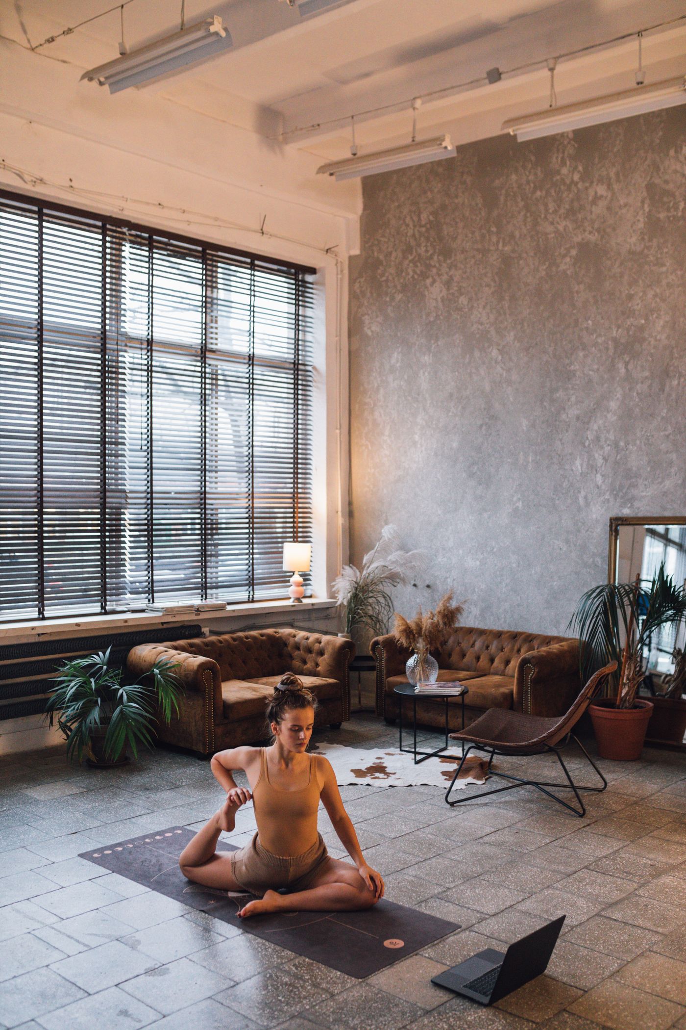 A woman stretching through a calm yoga sequence in her sunlit living room